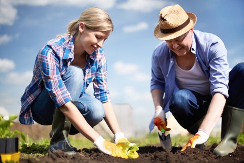 Community gardener tending an Euston planting bed, close-up of hands in soil