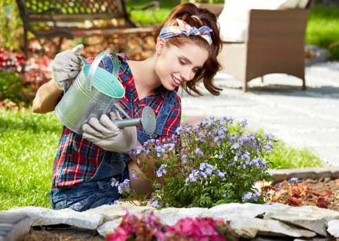 Team member in hi-vis clothing performing garden maintenance with safety gloves